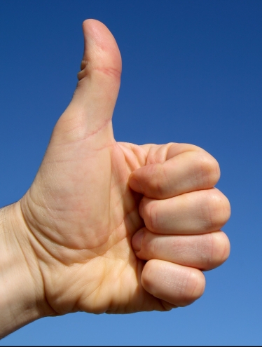 Thumbs up with blue sky background and space for text.